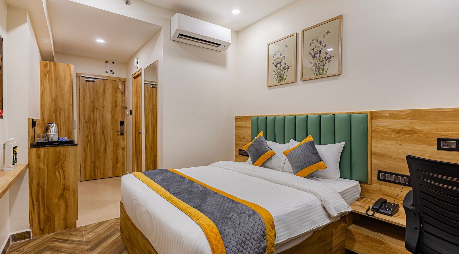 Lemonridge Hotels, KPHB | view of the hotel room showcasing the bed, TV, and a portion of the wall decor.